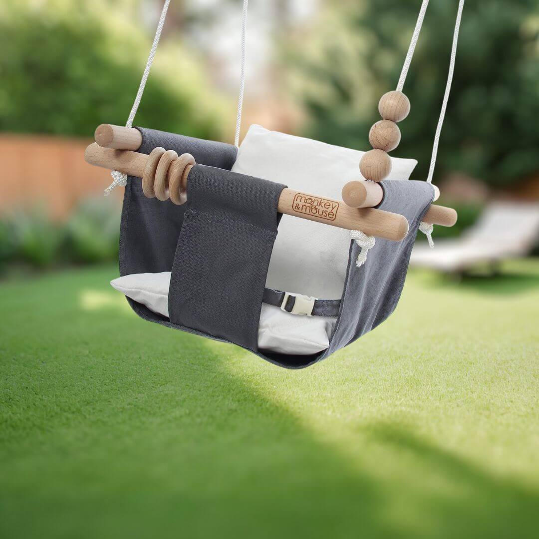 Monkey and Mouse brand baby swing in a backyard setting